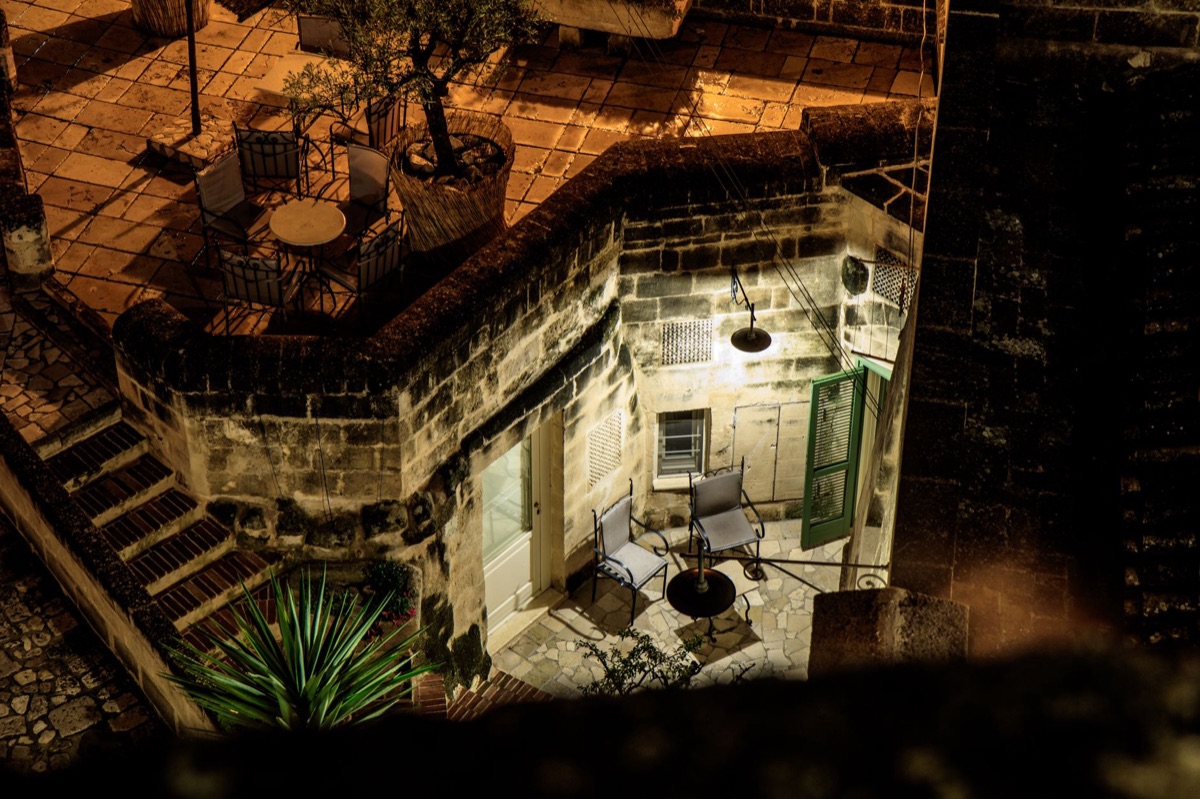 West End courtyard at night with illuminated signs and pedestrians