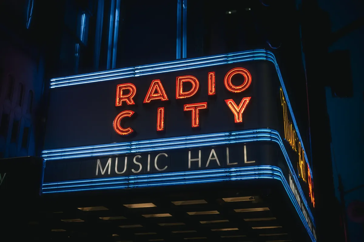 Neon lights of Radio City Music Hall in NYC, illuminated at night.